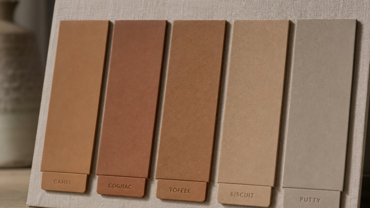 Five leather swatches — camel, cognac, toffee, biscuit, and putty — on linen board