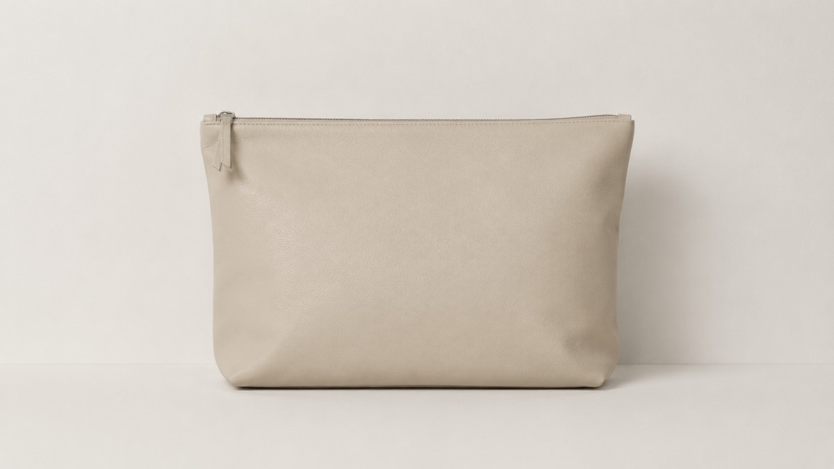 Leather pouch or pochette against a plain warm off-white wall