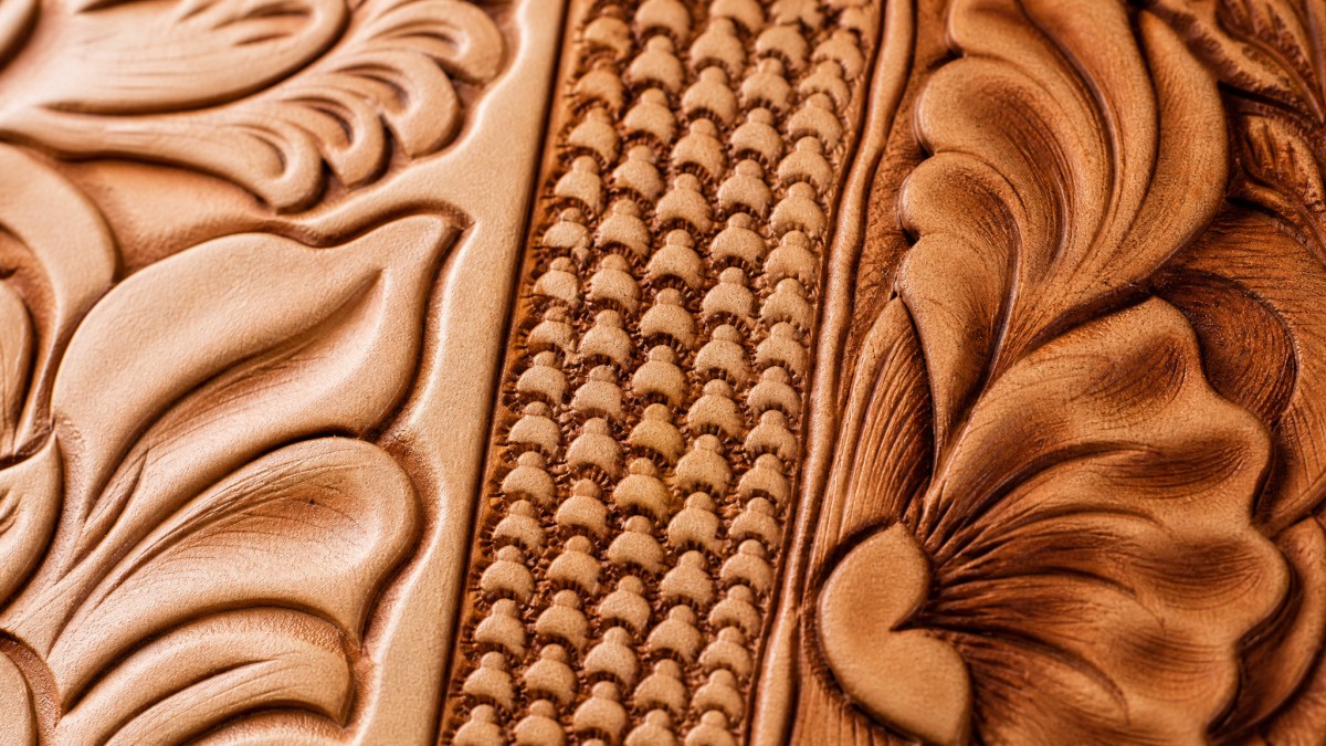 Macro view of beveling, backgrounding, and shading techniques on tooled leather